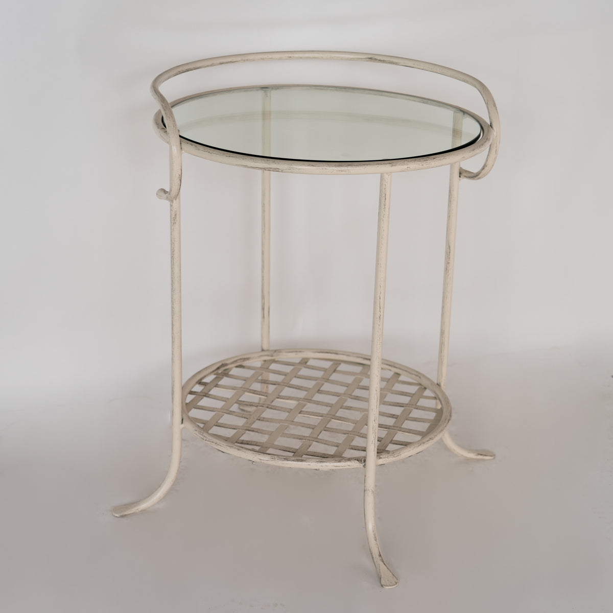 Bastogne bedside table with glass top, curved legs and lower shelf with diamond pattern, against a white background