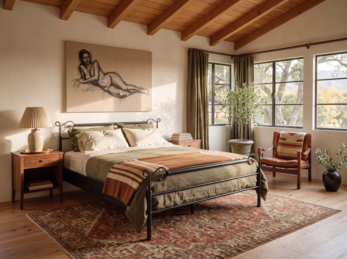 Cadiz smeedijzeren bed in zwart met krullen op de staanders, schuin vooraanzicht in een slaapkamer met houten balken