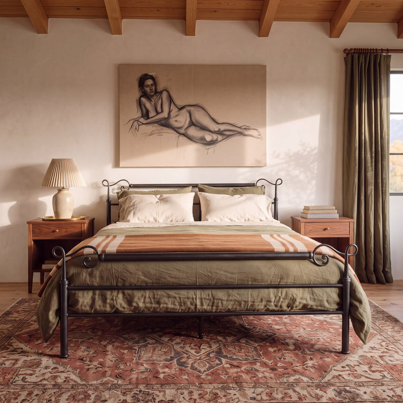 Vooraanzicht van het Cadiz smeedijzeren bed met olijfgroen beddengoed op een rood vloerkleed