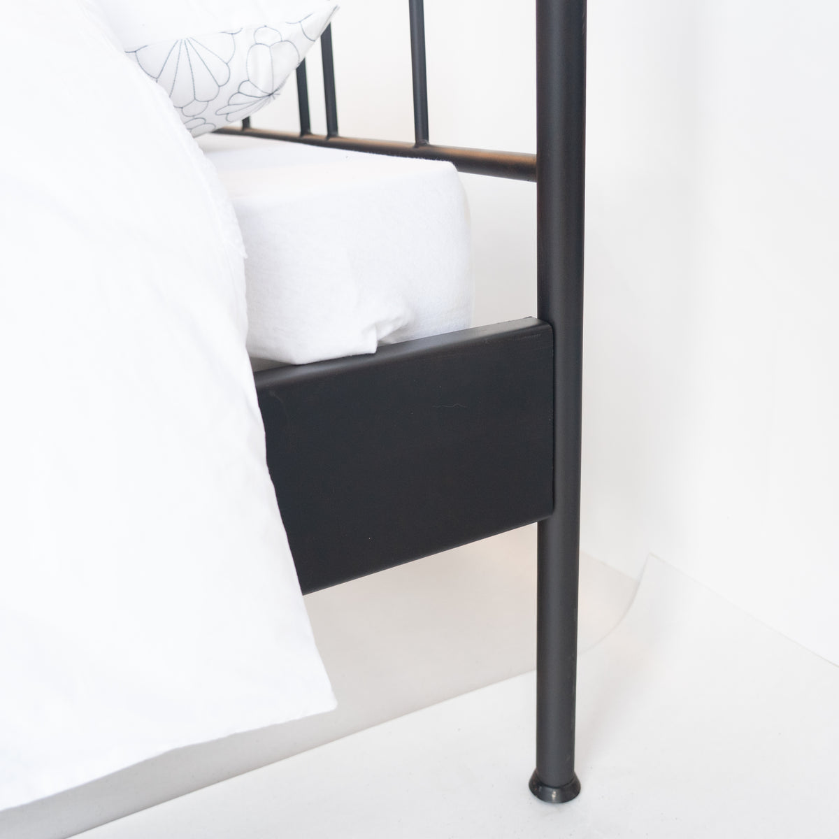 Detail des schwarzen Seitenholms und des Bettbeins von Veurne, das Bett mit weißer Bettwäsche bezogen