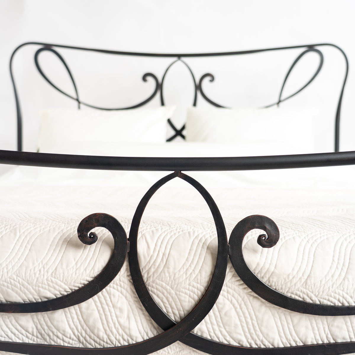 Detail des Fußteils am Bett Houffalize mit Spiralschnörkeln, das Kopfteil unscharf im Hintergrund