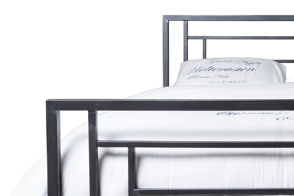 Fuß- und Kopfteil des Betts Hasselt in Schwarz mit weißer Bettwäsche mit Textaufdruck, Seitenansicht