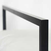 Close-up van strak zwart metalen frame van bed Genk met minimalistische vormgeving