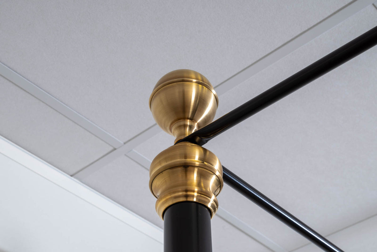 Brass ball finial on top of a black corner post with canopy rails of the Durham canopy bed showroom model 180x200cm