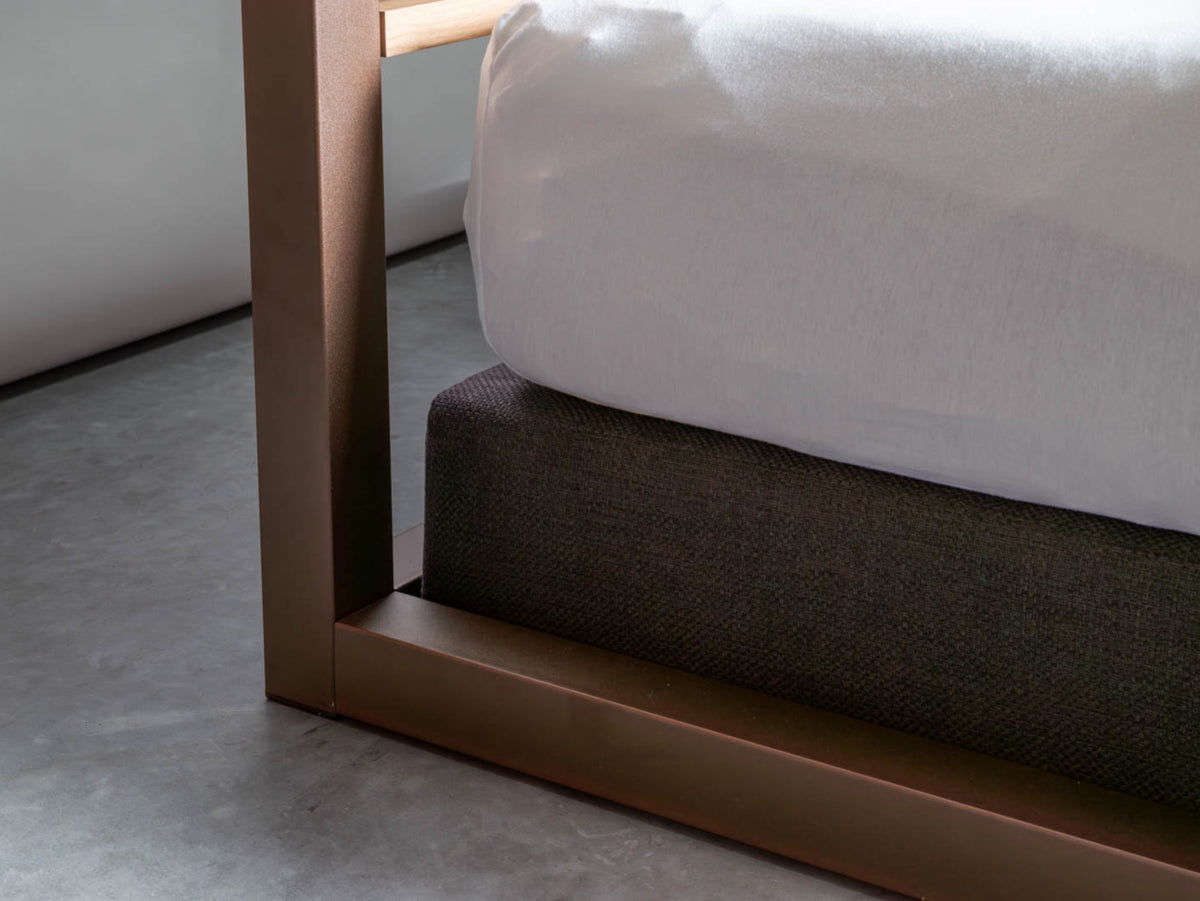 Detail of the post of The Loft canopy bed with headboard in metallic brown next to a dark grey base