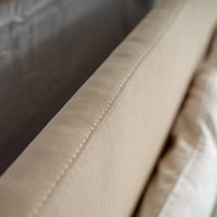 Detail precisie stikwerk op beige stoffering van bed Milano