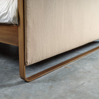 Close-up van metalen frame en beige textiel van bed Milano met strakke lijnen