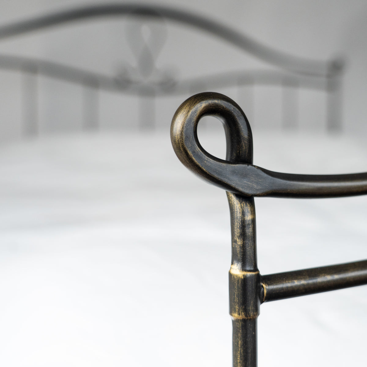 Detail des eingerollten oberen Endes eines Pfostens am Bett Navarra in Schwarz-Bronze patiniert