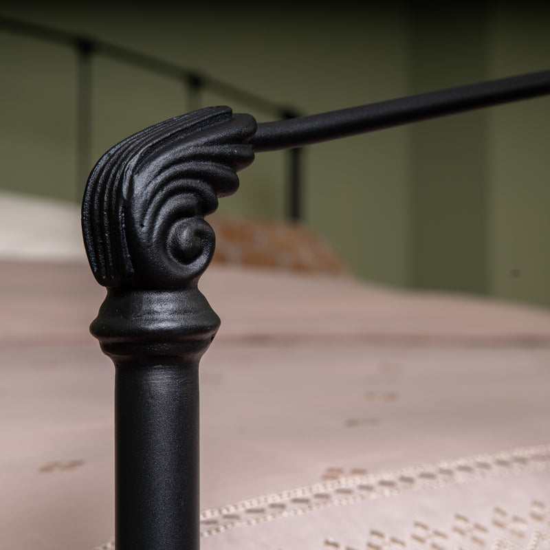 Élément décoratif en fonte noire du lit Stavelot avec détails traditionnels en spirale