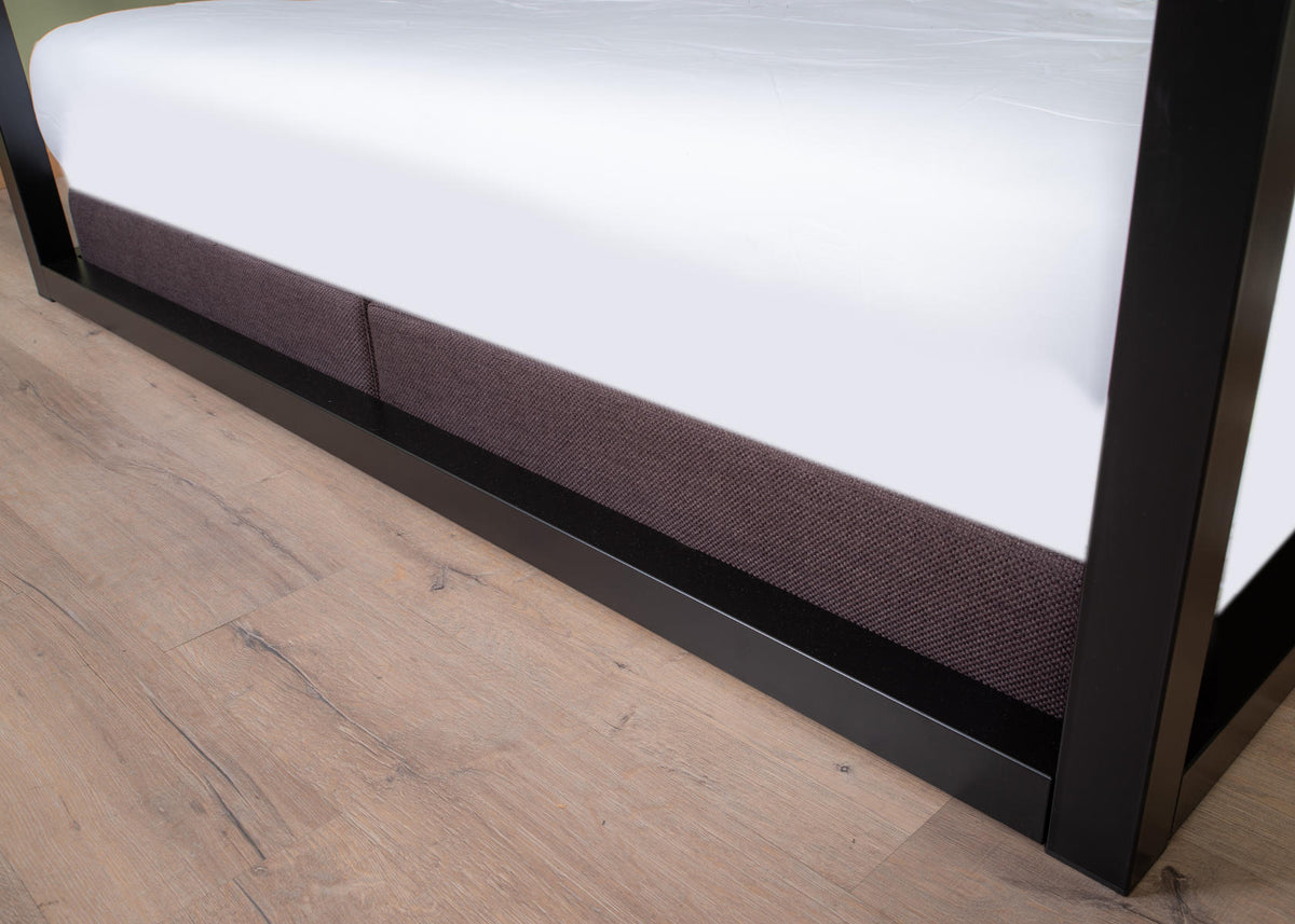 Detail of the black underframe of The Loft canopy bed without headboard with grey upholstered surround