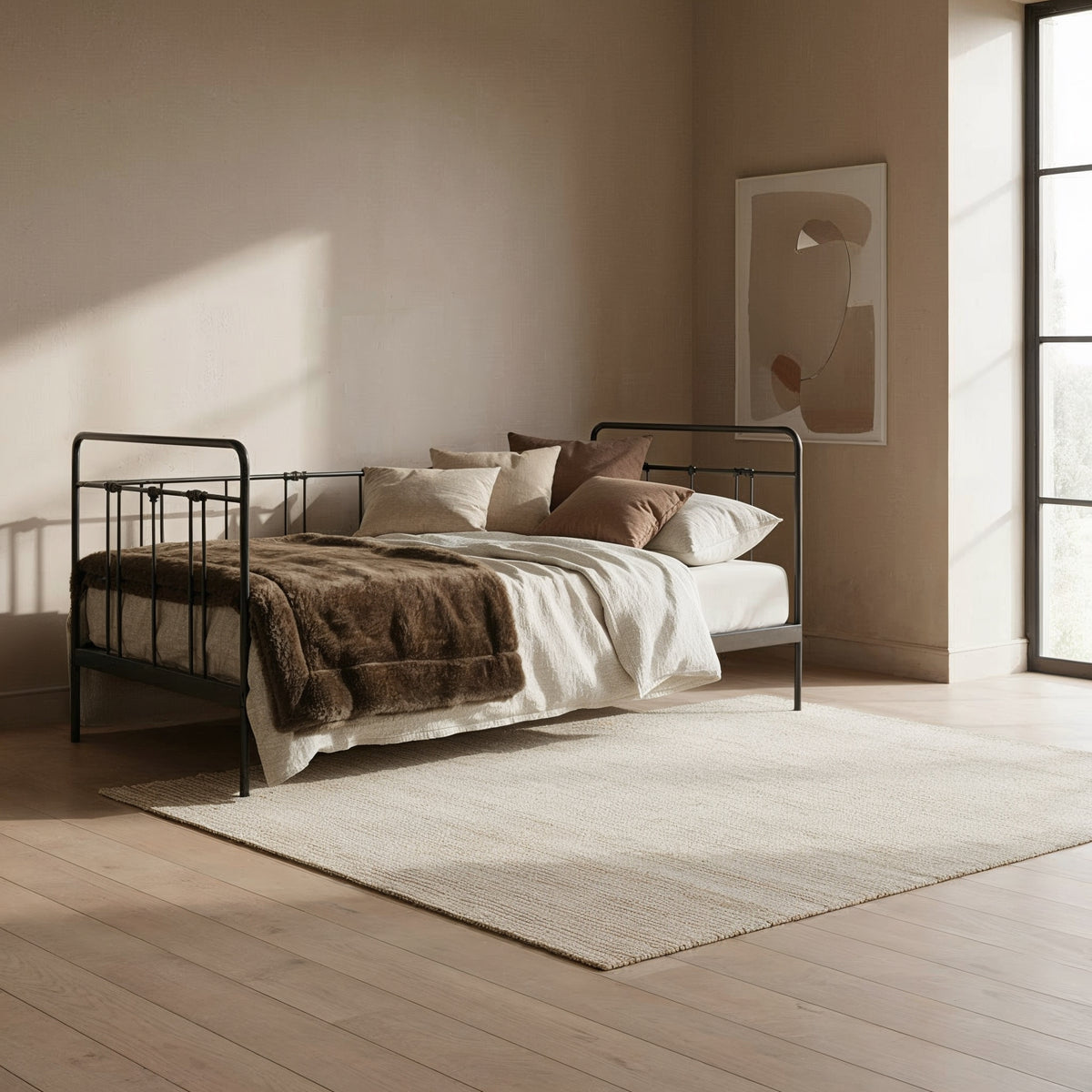 Veurne metal single bed in black with spindles, used as a daybed against the wall in a light room with wooden floor