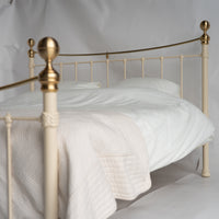 Zijaanzicht metalen bed Wellington met crèmewitte afwerking en gouden details