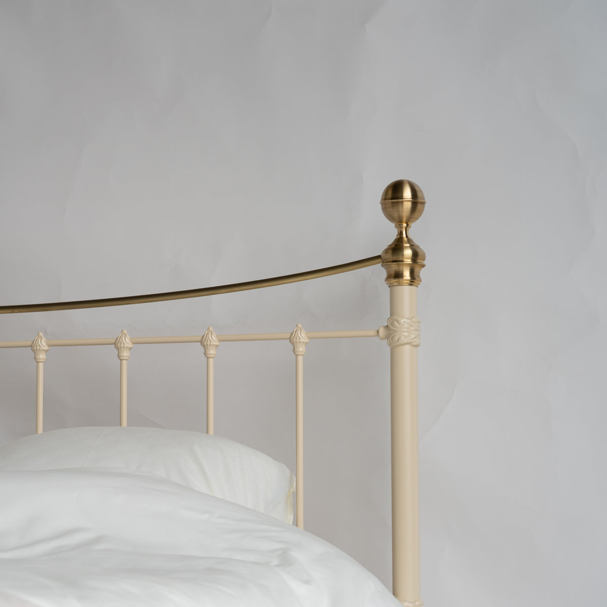 Detailansicht des Kopfendes vom Metallbett Wellington mit goldenem Zierknauf und Streben