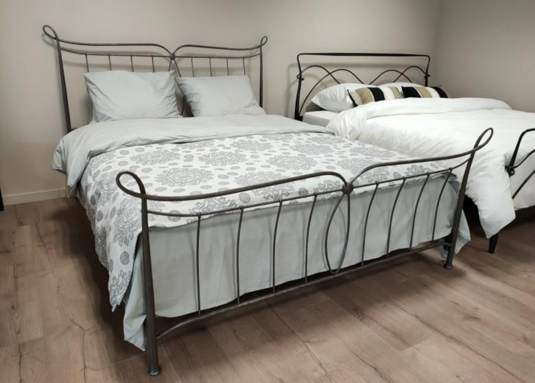 Antibes showroom model 160x200 in grey metal in the showroom, with another metal bed to the right
