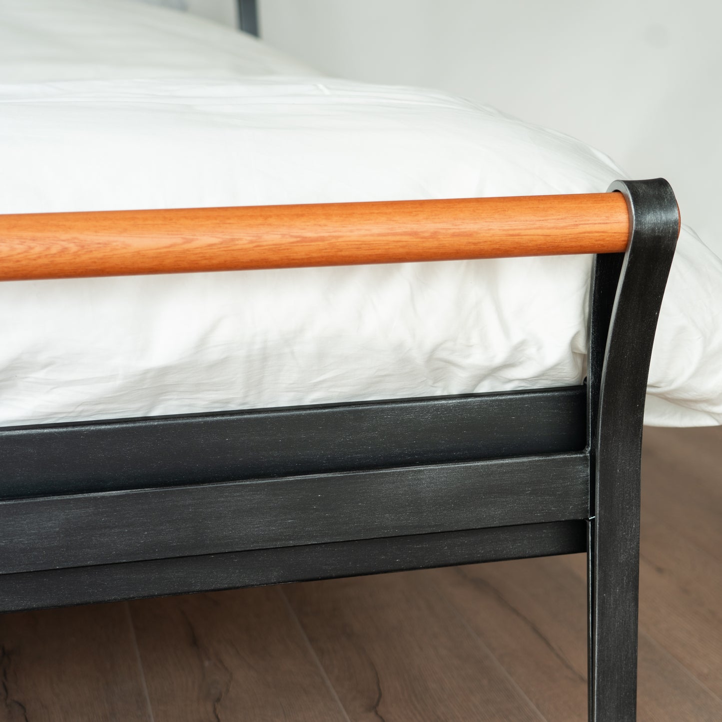 Detail verbinding houten buis en zwart metalen frame van bed Cudillero