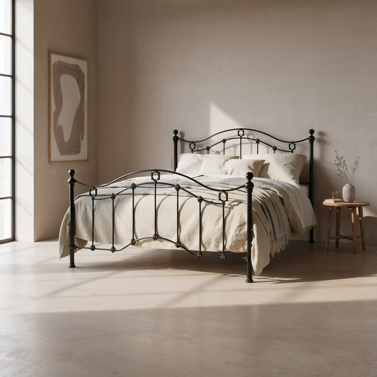 Metallbett Middleton in Schwarz mit geschwungenem Kopf- und Fußteil und Zierornamenten, in einem hellen Schlafzimmer