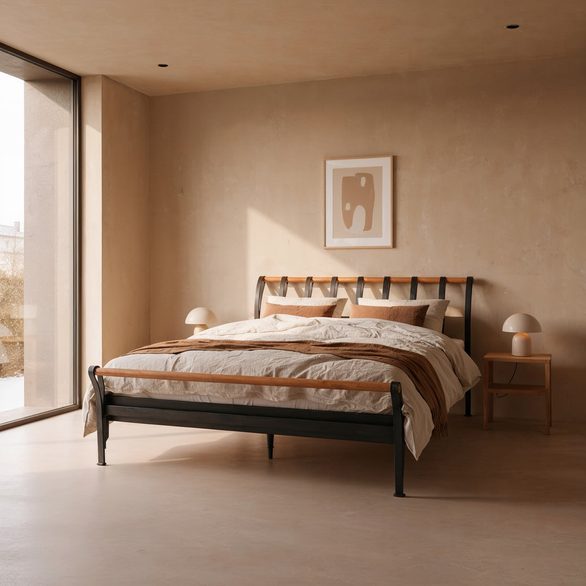 Cudillero metal bed in black with wood-coloured tubes on the headboard and footboard, in a warm, light bedroom