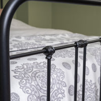 Black metal tube frame of bed Veurne with traditional connecting buttons