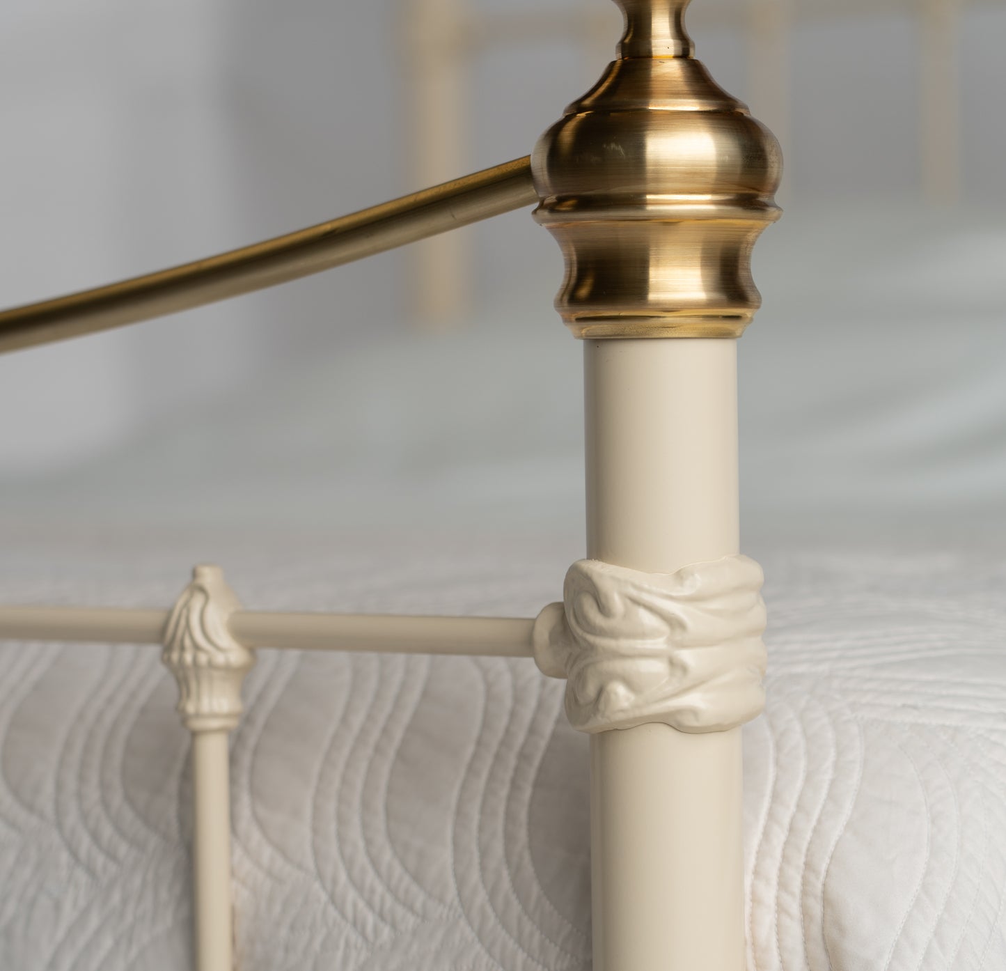 Detail view feed end metal bed Wellington with gold decorative knob and bars