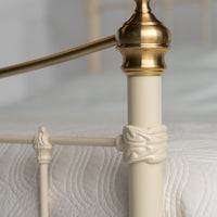 Detail view feed end metal bed Wellington with gold decorative knob and bars